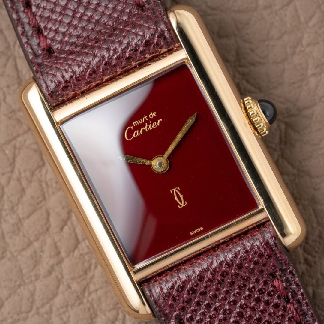 A Must de Cartier Tank in vermeil with a deep red lacquer dial and gold hands, on a burgundy lizard strap.