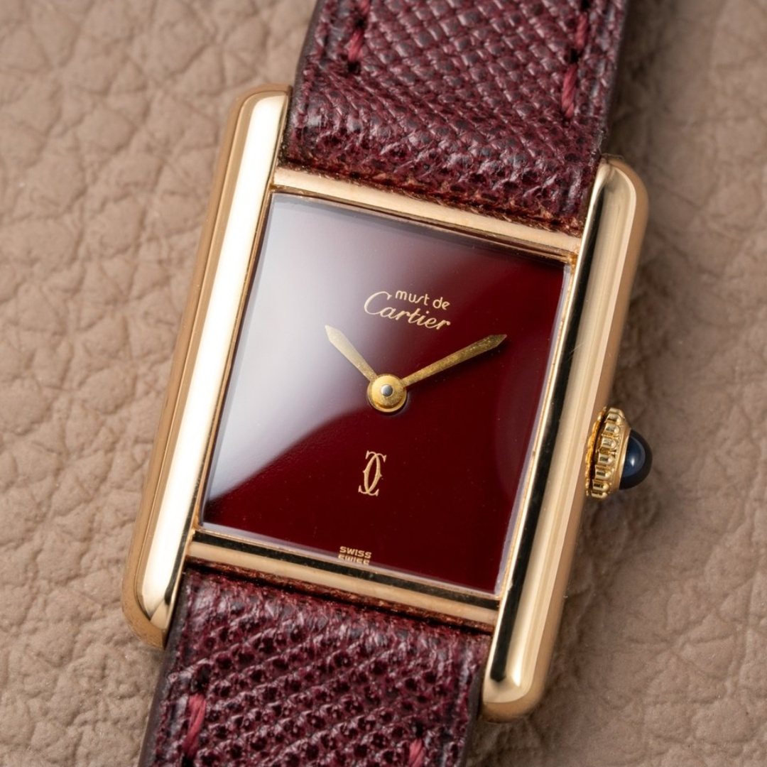 The watch at a three-quarter angle, showing the polished brancards either side of the dial.