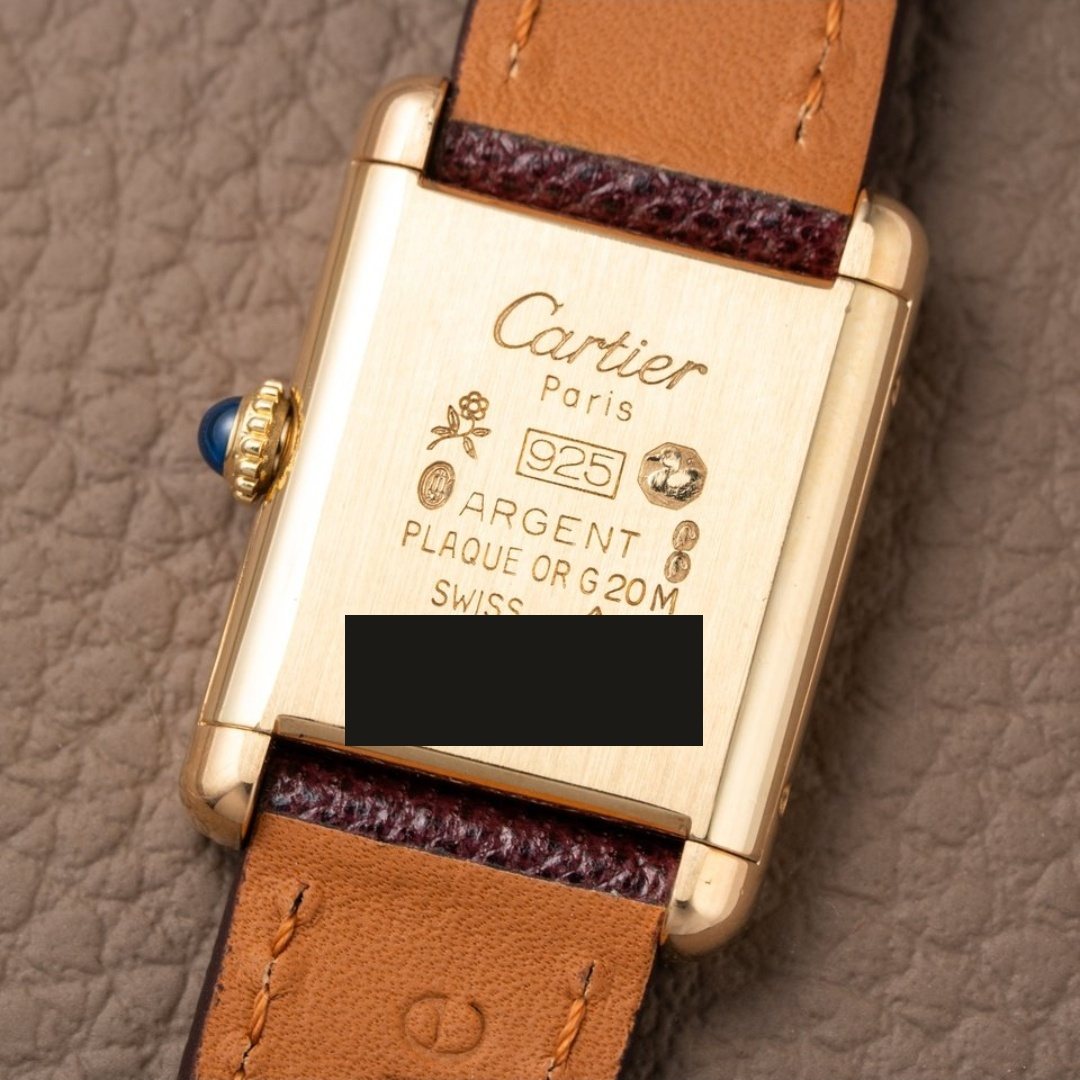 The case back, signed Cartier Paris with the vermeil hallmarks. The case number is blacked out.