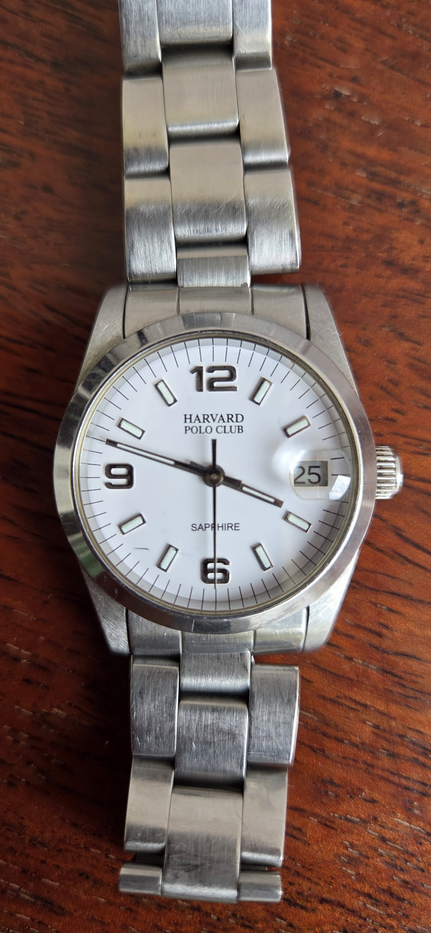 A steel Harvard Polo Club wristwatch with a silver dial and a date window, on a steel bracelet.