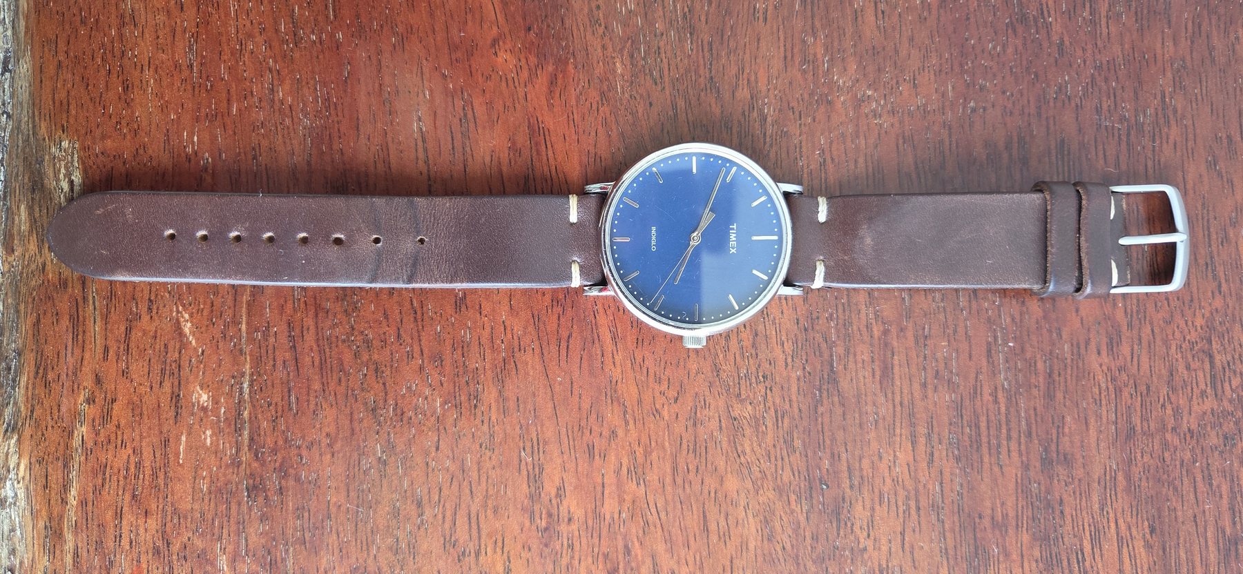 The whole watch laid out flat with the leather strap extended.