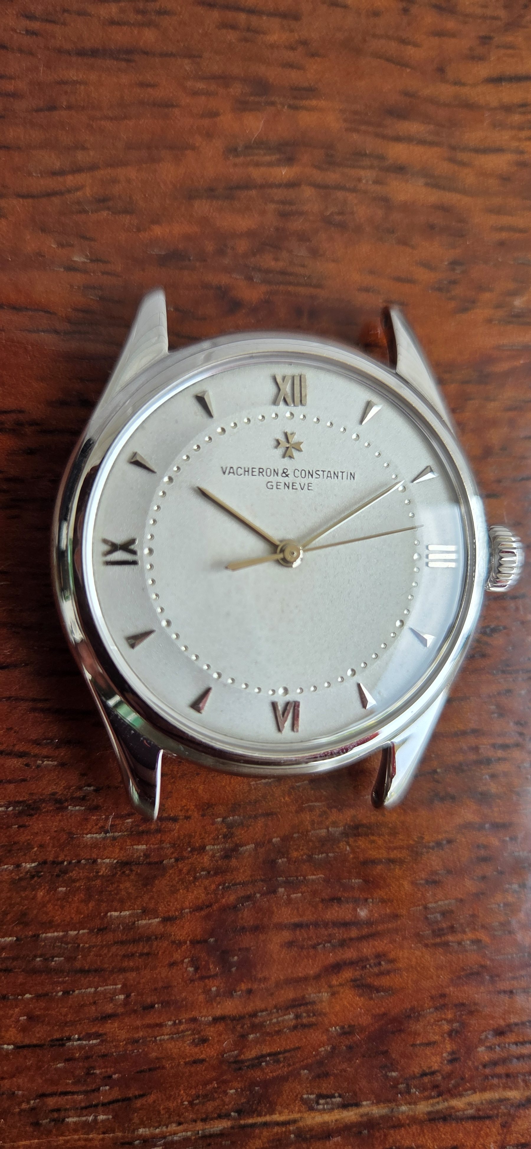 The silvered dial square-on, applied Roman numerals at the quarters and faceted darts between them.