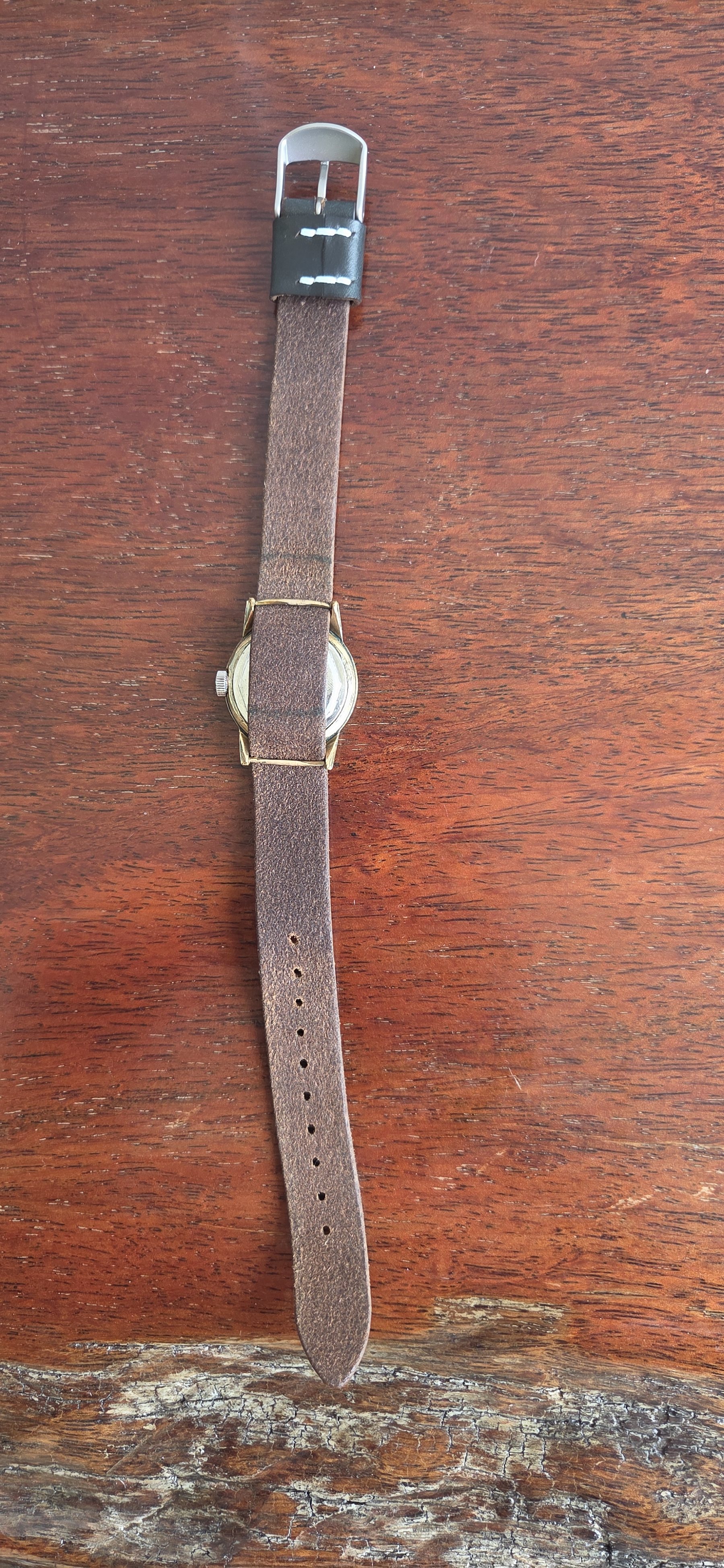 The whole watch laid out flat with the strap extended.